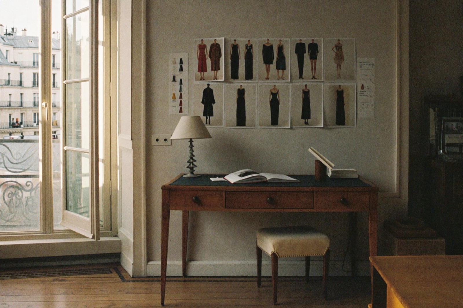 Parisian workspace with a moodboard wall of fashion tearsheets and fabric swatches